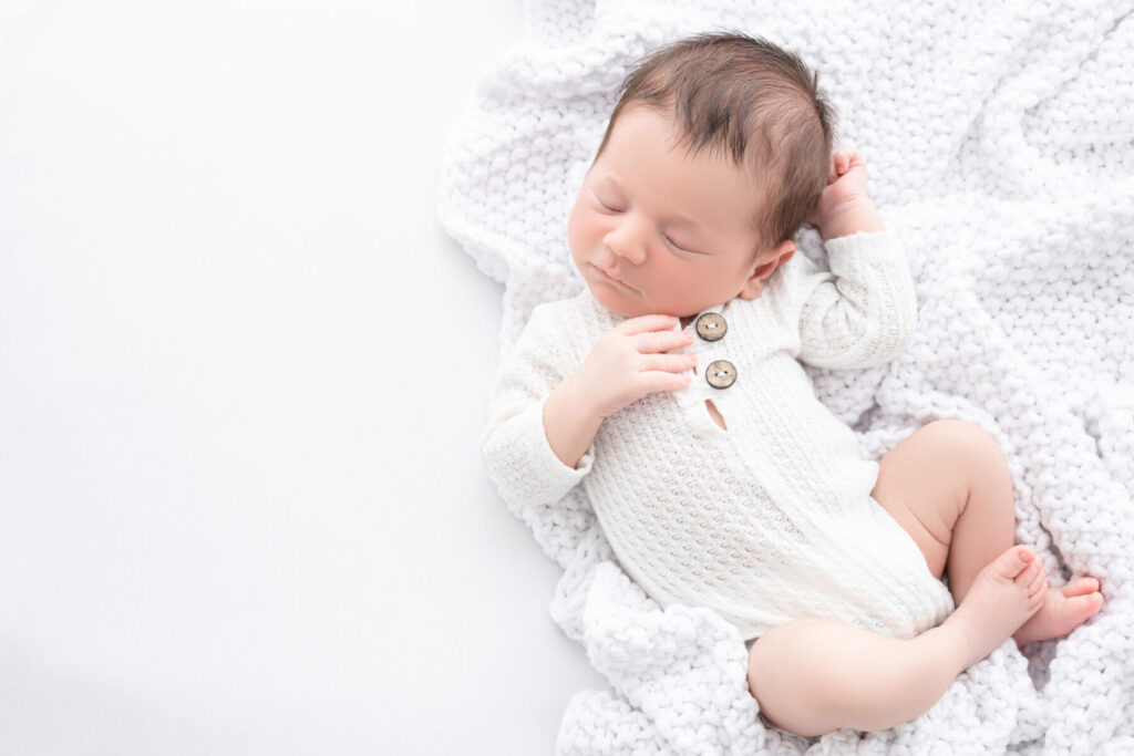 Newborn baby sleeping in blanket during newborn photoshoot